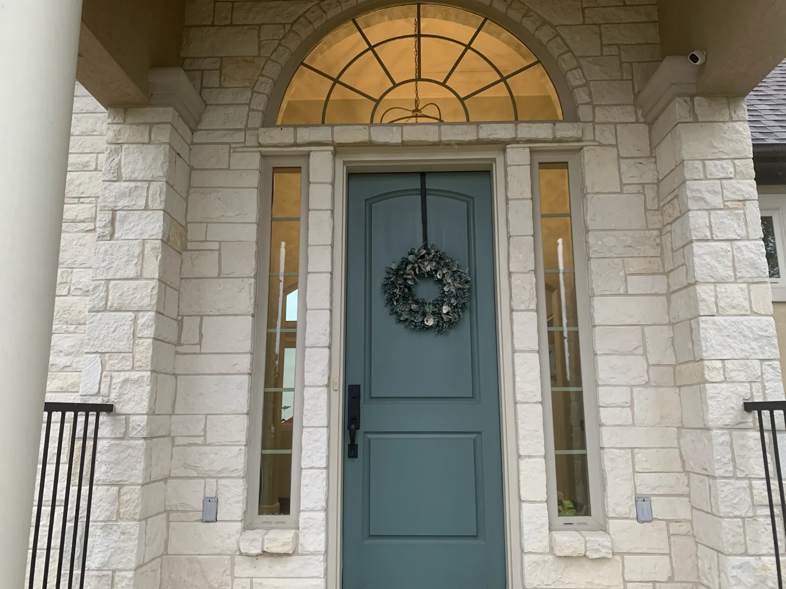 Sage-green front door with a wreath, installed by SunSmart